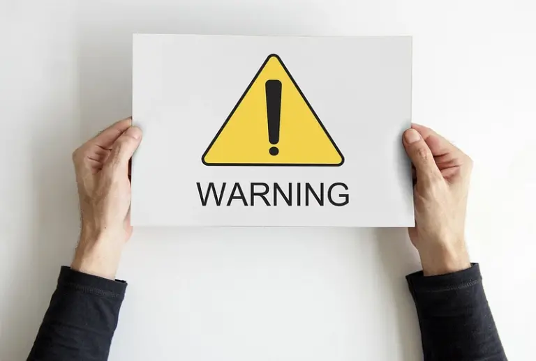 Elde tutulan, uyarı işareti ve warning yazısı içeren kağıt
